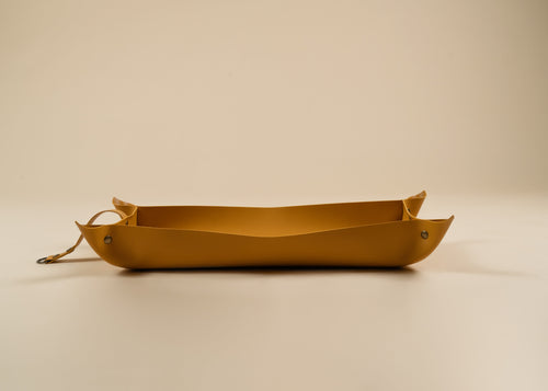 30x60cm in size, A yellow leather tray with a loop handle on one end, photographed on a clean, solid beige background.