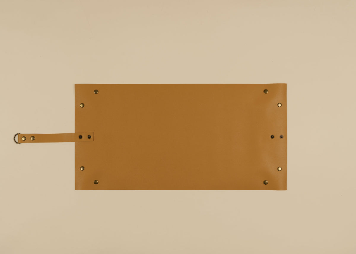30x60cm in size, A yellow leather rectangular sleeve or pouch with a strap on the left side and brass-tone rivets, shown flat against a solid beige background.